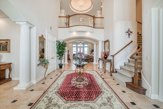 entrance foyer with a towering ceiling and decorative columns