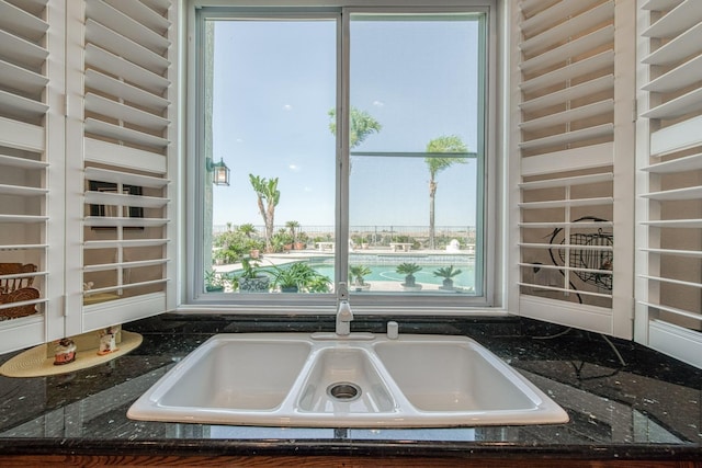 kitchen featuring dark stone countertops and sink