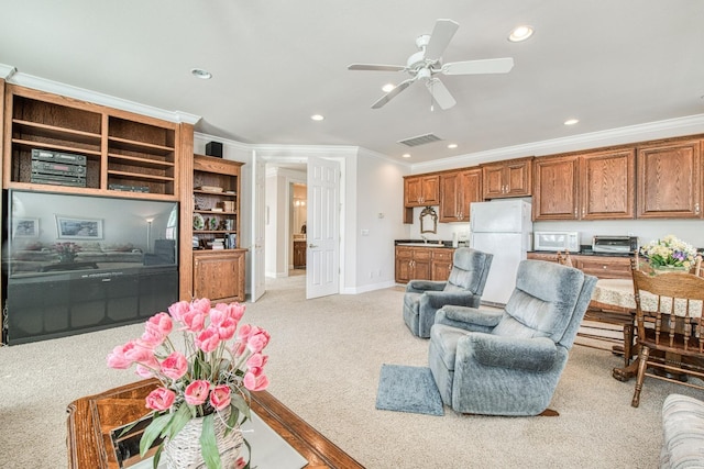 living room featuring light colored carpet, ceiling fan, and ornamental molding