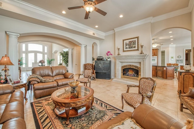 tiled living room with crown molding, ceiling fan, and ornate columns