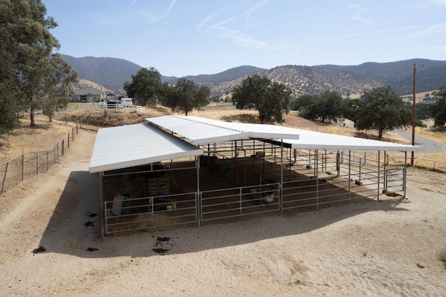 view of horse barn with a rural view and a mountain view