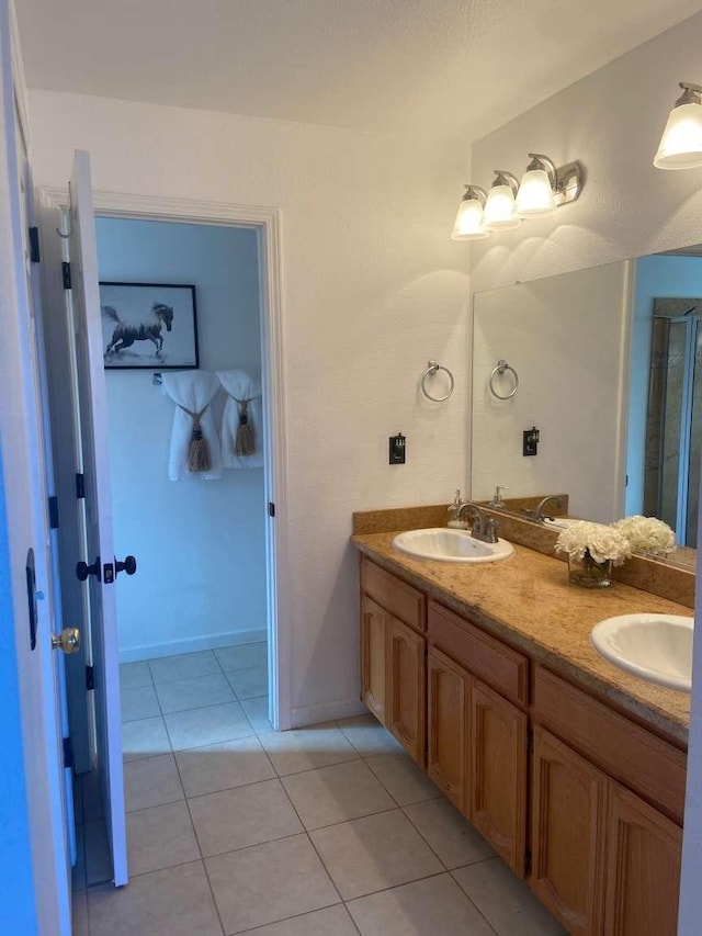 bathroom with a sink, double vanity, and tile patterned flooring