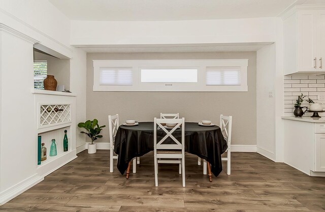 dining room with dark wood finished floors and baseboards