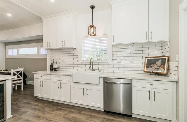 kitchen featuring dark wood-style flooring, decorative light fixtures, white cabinets, a sink, and dishwasher