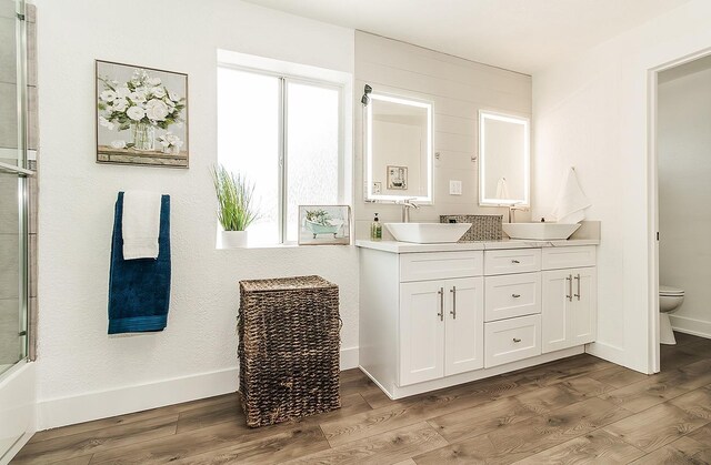 full bathroom with toilet, a sink, and wood finished floors