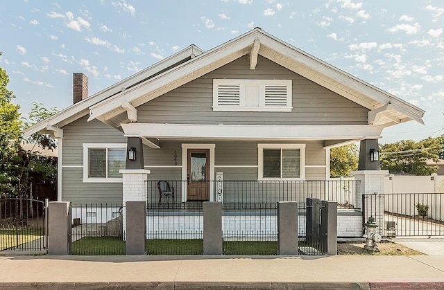 view of front of house with covered porch and a fenced front yard