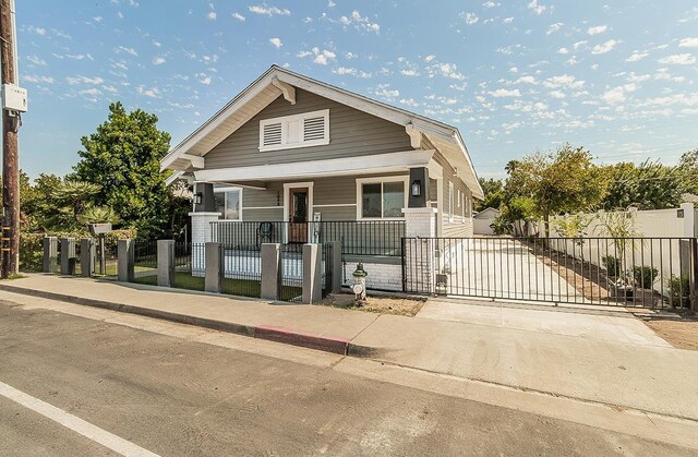 view of front of property featuring a fenced front yard and a gate