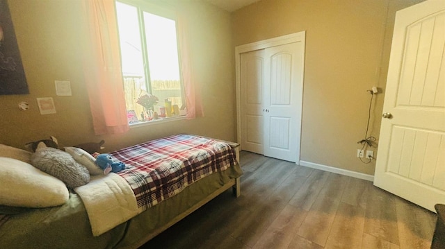 bedroom with wood finished floors and baseboards