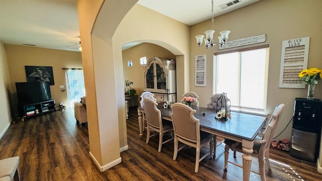 dining area with baseboards, visible vents, arched walkways, dark wood-type flooring, and ceiling fan with notable chandelier