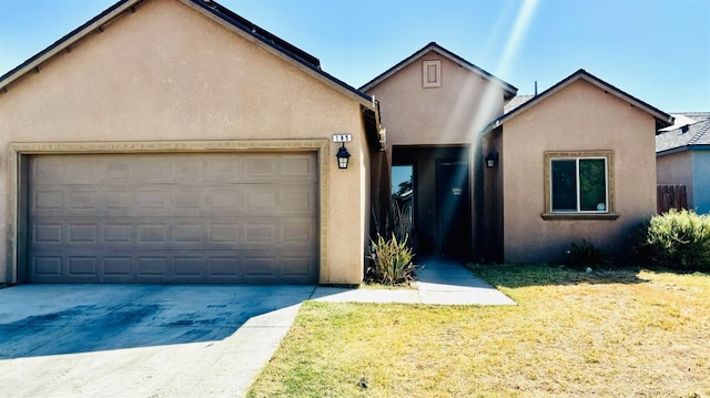 view of front of house featuring driveway, an attached garage, and stucco siding