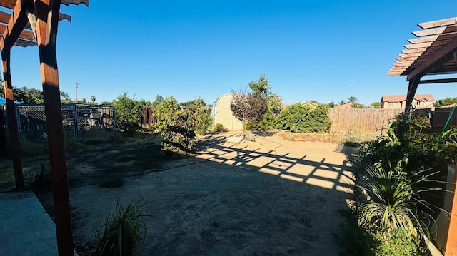 view of yard featuring a patio, a fenced backyard, a storage unit, an outdoor structure, and a pergola