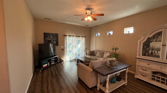 living area featuring dark wood-style floors, baseboards, visible vents, and a wealth of natural light