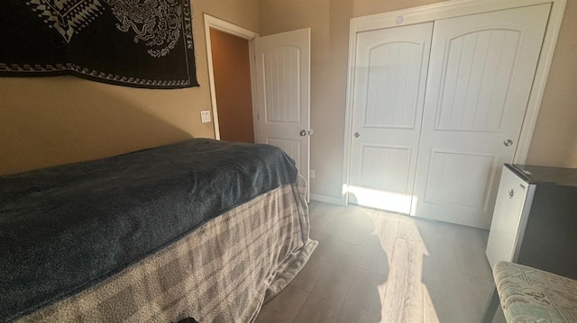 bedroom featuring a closet, wood finished floors, and baseboards