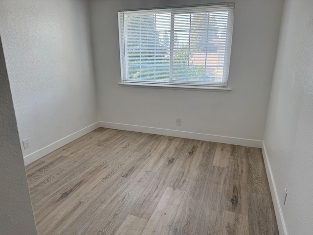 empty room with baseboards and wood finished floors