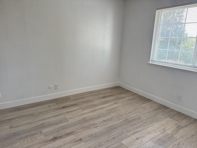 spare room with light wood finished floors and baseboards