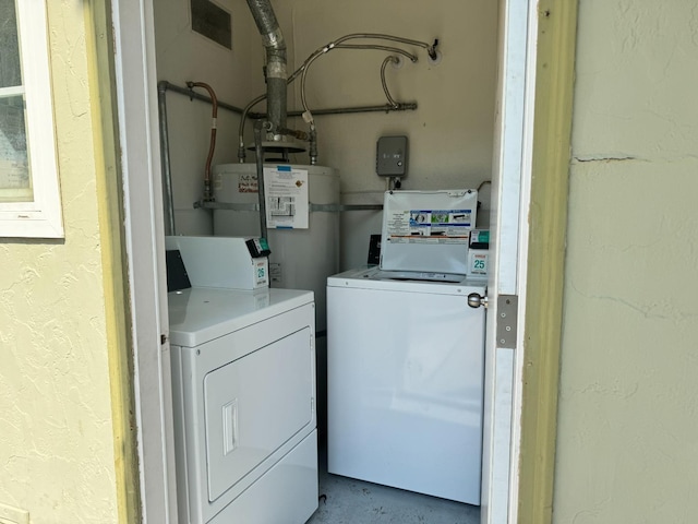 washroom featuring a textured wall, laundry area, independent washer and dryer, and strapped water heater