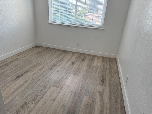 unfurnished room featuring wood finished floors and baseboards