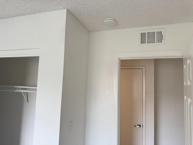 unfurnished bedroom featuring a closet, visible vents, and a textured ceiling