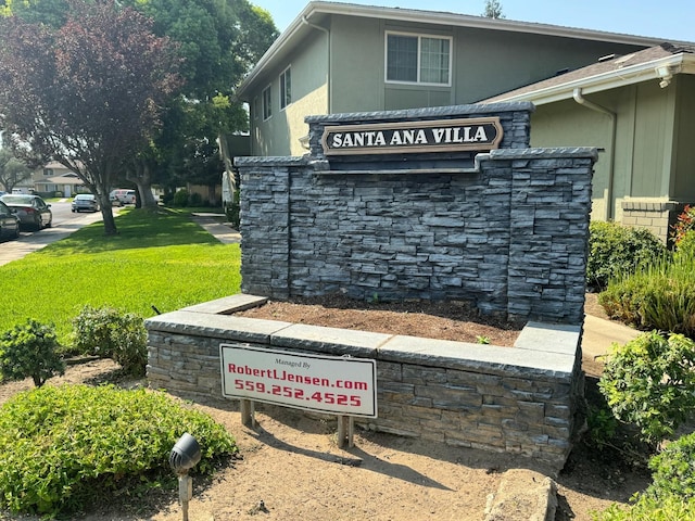 community / neighborhood sign featuring a lawn