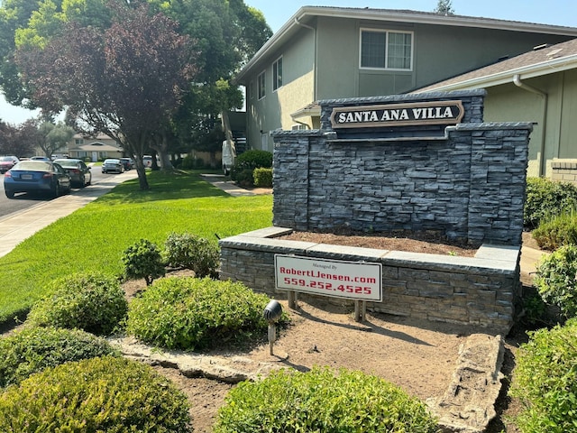 community / neighborhood sign featuring a lawn