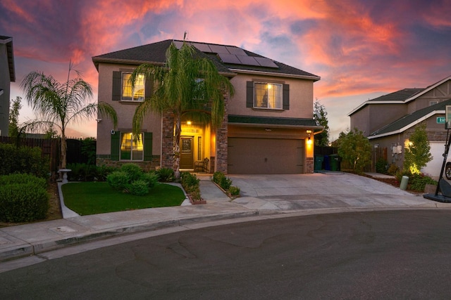 view of front of home featuring a lawn, solar panels, and a garage