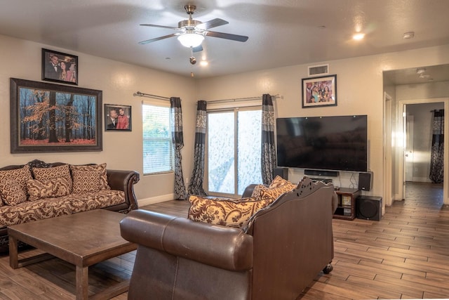 living room featuring wood-type flooring and ceiling fan