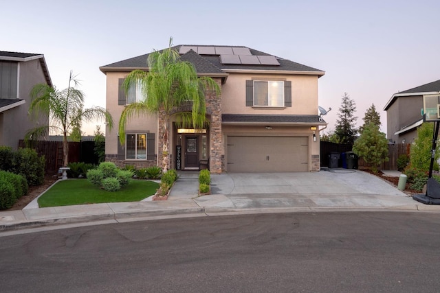 view of front of home with a garage, solar panels, and a lawn