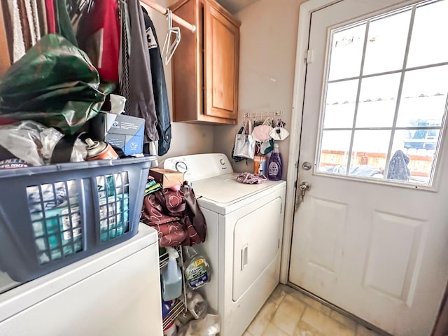 laundry room featuring separate washer and dryer and cabinets