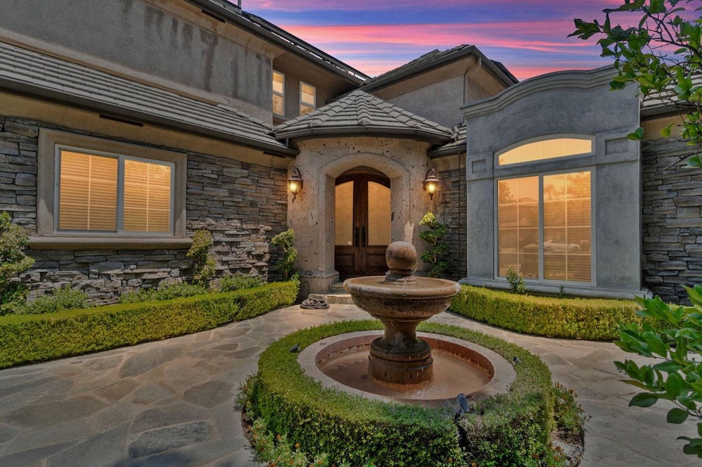 exterior entry at dusk with a patio