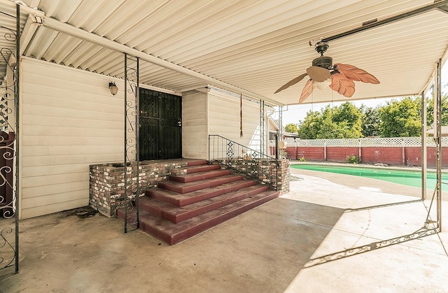 entrance to property featuring ceiling fan, a fenced in pool, and a patio