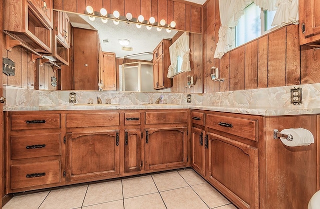 bathroom with tasteful backsplash, tile patterned flooring, and vanity