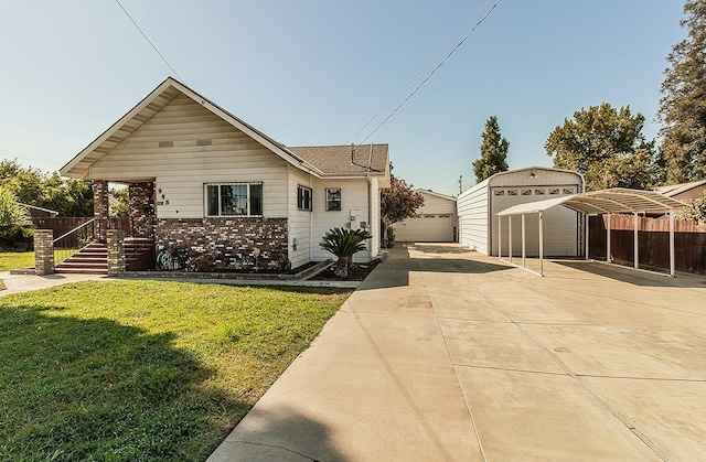 view of front of house with a front yard, a garage, and an outdoor structure