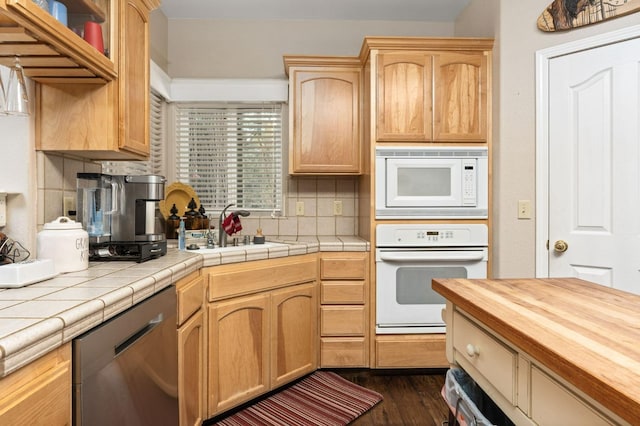 kitchen featuring tasteful backsplash, white appliances, tile counters, dark hardwood / wood-style floors, and sink