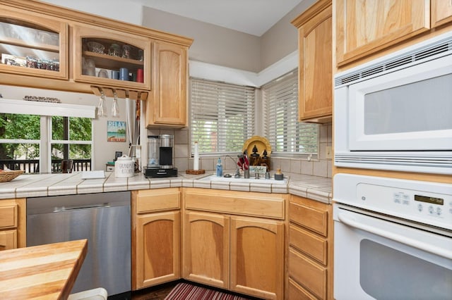 kitchen with tile counters, white appliances, and a wealth of natural light