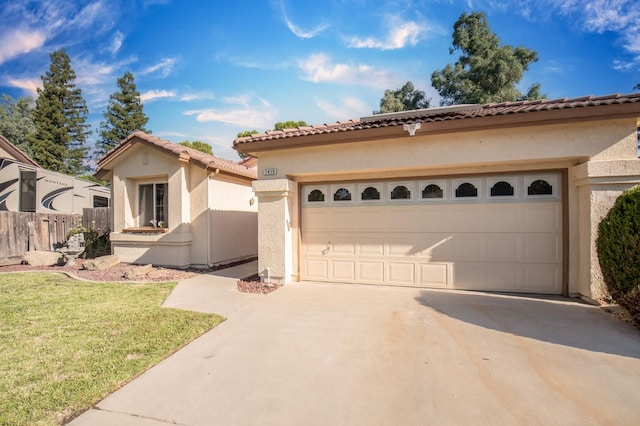 mediterranean / spanish house featuring a garage and a front lawn