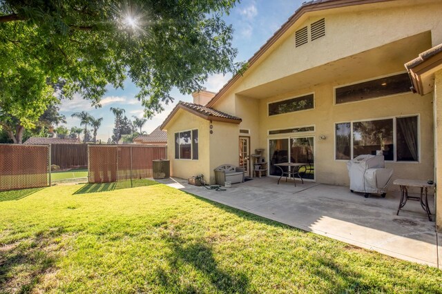 rear view of house with a patio and a yard