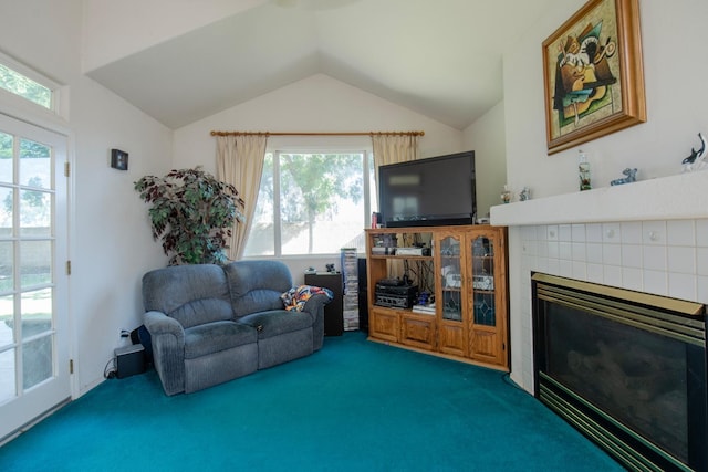 living room featuring lofted ceiling, plenty of natural light, carpet flooring, and a tiled fireplace