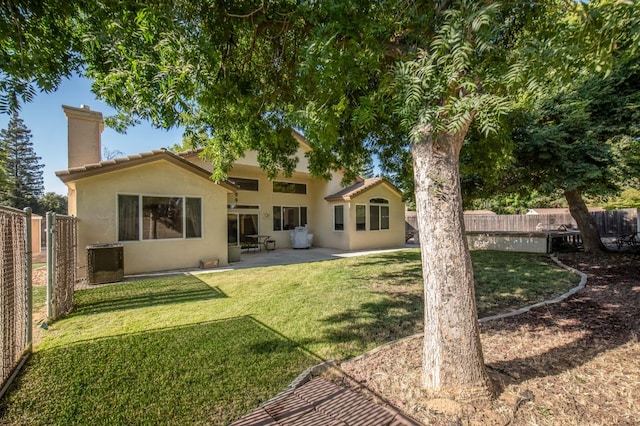 rear view of house with central AC, a patio, and a lawn