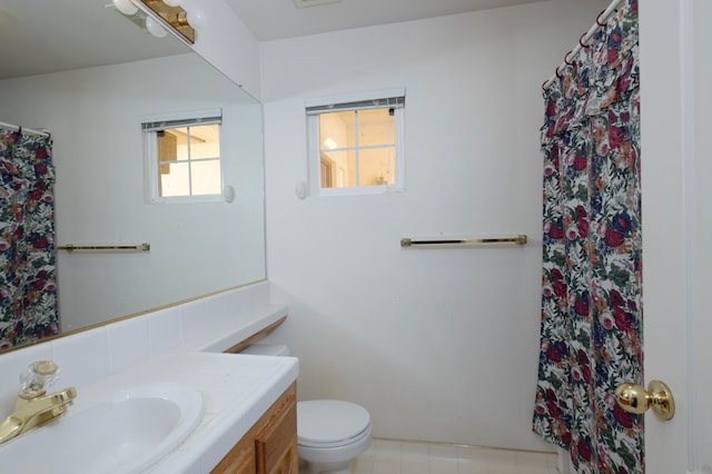 bathroom with vanity, plenty of natural light, toilet, and tile patterned floors