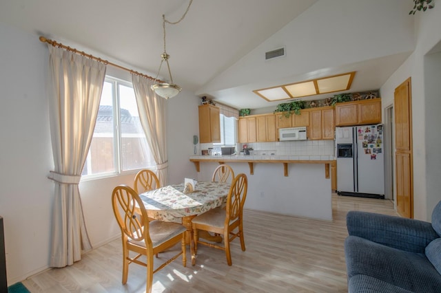 dining space with lofted ceiling and light hardwood / wood-style floors