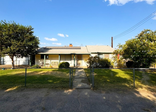 ranch-style house with a fenced front yard, solar panels, a front lawn, and a gate