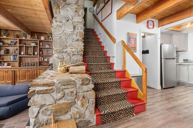 staircase with wood ceiling, beamed ceiling, and wood-type flooring