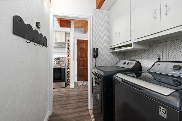 laundry room with dark wood-type flooring, independent washer and dryer, and cabinets