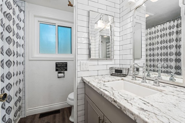 bathroom with a shower with curtain, vanity, toilet, and hardwood / wood-style flooring