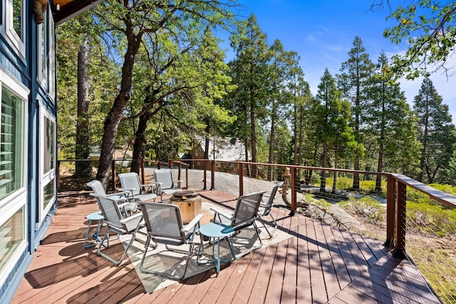 wooden terrace featuring an outdoor fire pit