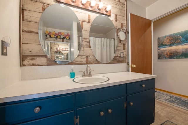 bathroom with vanity, tile patterned flooring, and wood walls