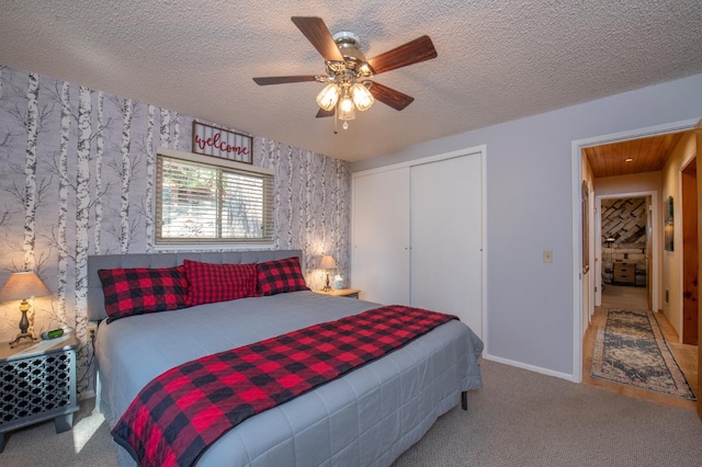 bedroom with a closet, a textured ceiling, carpet flooring, and ceiling fan