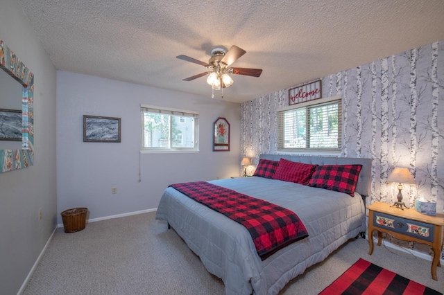 bedroom featuring ceiling fan, light carpet, and a textured ceiling