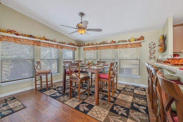 dining room with wood-type flooring, baseboards, vaulted ceiling, and ceiling fan