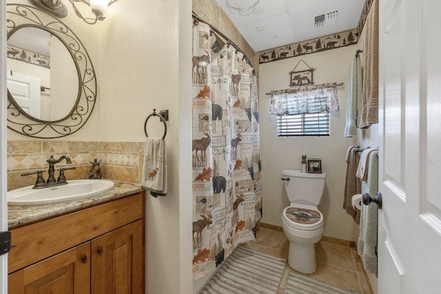bathroom featuring toilet, vanity, tile patterned flooring, visible vents, and decorative backsplash